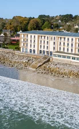 Vue aérienne du Belambra Clubs Morgat - Le Grand Hôtel de la Mer en bord de plage.