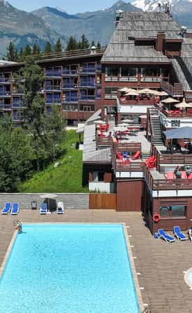 Piscine extérieure et pataugeoire au pied des terrasses du club Belambra à Arc 1800.
