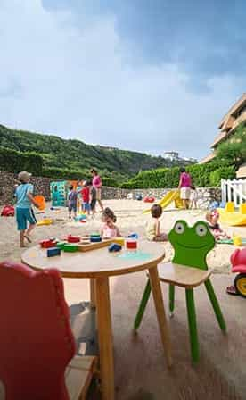 Enfants jouant dans le sable avec des animatrices Belambra