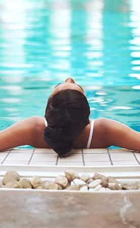 Femme en position détente dans la piscine