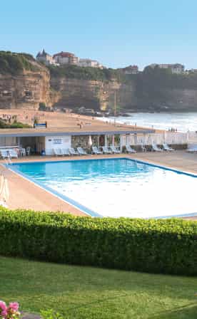 Piscines extérieures du club Belambra Anglet « La Chambre d'Amour » avec vue sur la plage et le phare de Biarritz.