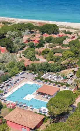 Vue aérienne du club Belgodère Belambra en bord de mer avec piscine extérieure et accès direct à la plage.