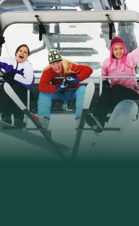 Enfants en tenue de ski sur un télésiège, séjour à la montagne