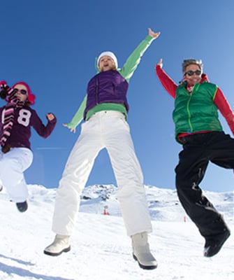 Skieurs heureux sautant dans la neige