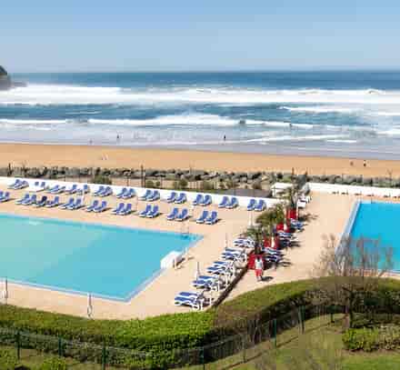 Piscines extérieures du club Anglet Belambra avec vue sur la plage et l'océan.