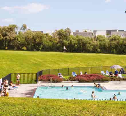Piscine extérieure et transats dans les jardins du club Belambra à Guidel-Plages.