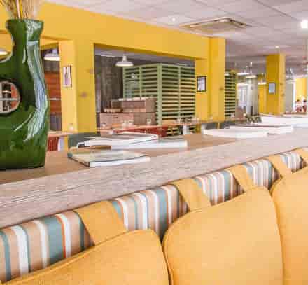 Espace bar du club Belgodère Belambra avec banquettes confortables et décoration contemporaine.