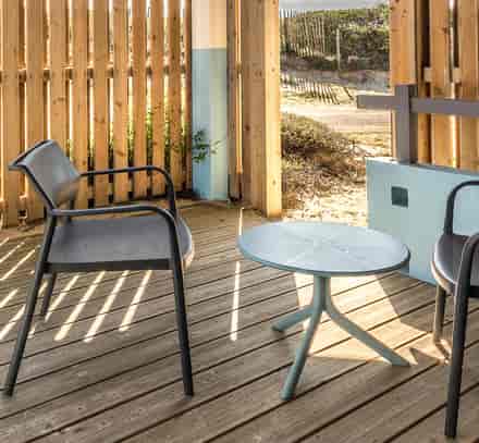 Terrasse abritée avec deux fauteuils et une table basse dans un hébergement Belambra à Seignosse.