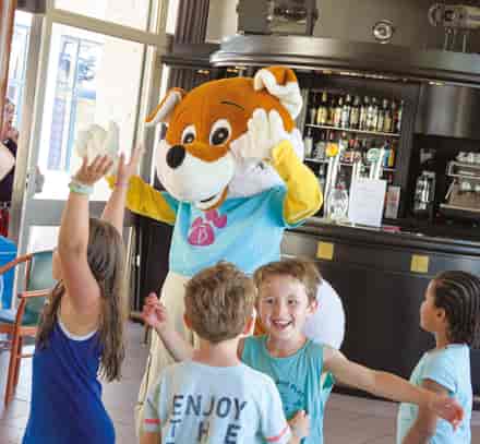 Des enfants participent à une animation avec une mascotte et des animatrices Belambra.