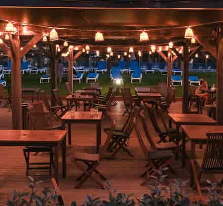 Terrasse du restaurant du club Belambra Borgo Pineto en soirée, avec ambiance conviviale et éclairages chaleureux.