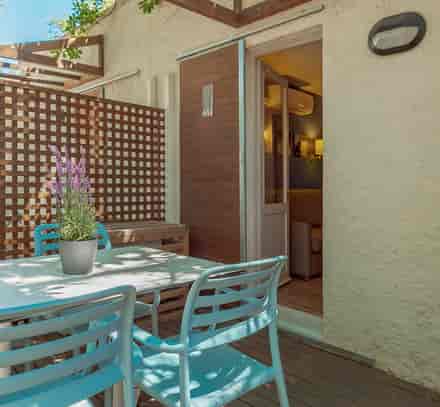 Terrasse privative avec table et chaises devant un hébergement Belambra au Pradet.